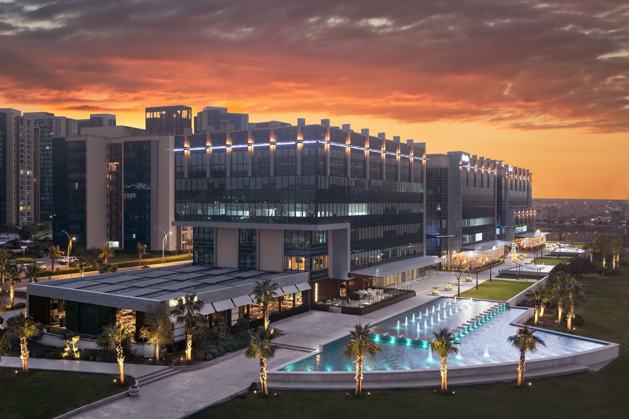 Modern office building and fountains at sunset